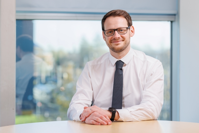 Image of SPA Head of Change and Operational Scrutiny, Scott Ross, sitting at an office desk.